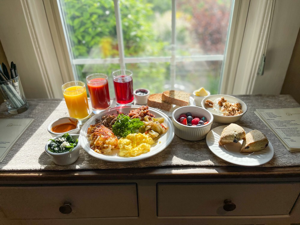 A spread of breakfast foods on a countertop in front of a window